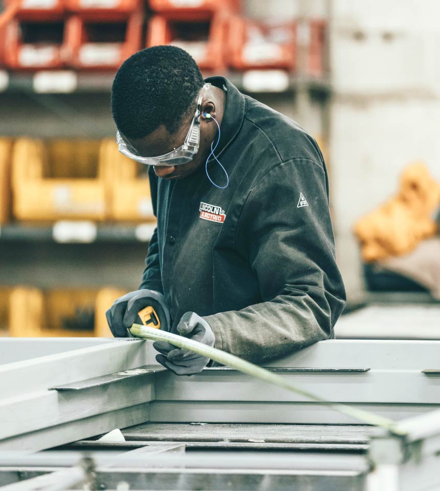 Man Using Measuring Tape in Factory Setting Brasov stainless steel welding